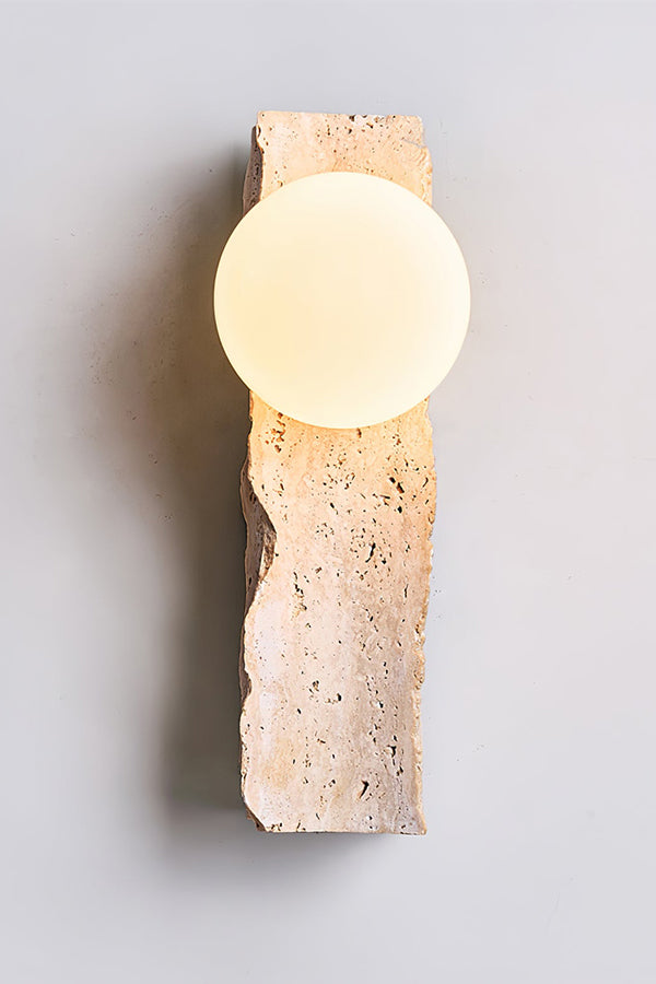 Front view of lit travertine block wall sconce | Yellow Travertine, Metal, Glass | Detailed shot against a grey studio background | vexa lamps