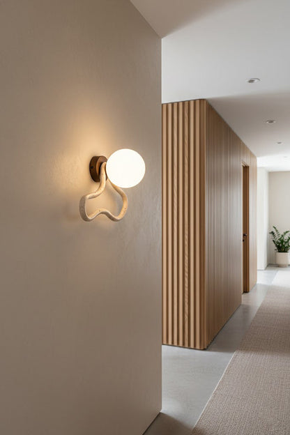 Travertine flow sconce providing warm light in a hallway | Travertine, Glass, Wood | Interior scene with minimalist wooden accents | vexa lamps