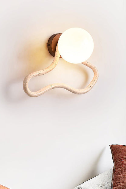 Warm glow from a travertine flow wall lamp | Travertine, Glass, Wood | Close-up showing the organic travertine loop | vexa lamps