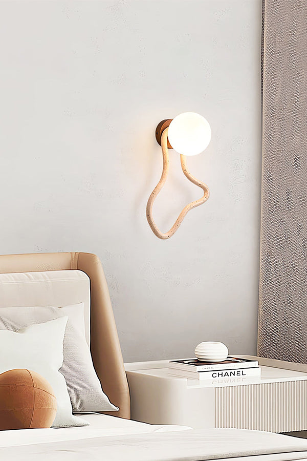 Organic shape travertine wall light in a modern bedroom | Travertine, Glass, Wood | Mounted next to a bed with neutral tones | vexa lamps