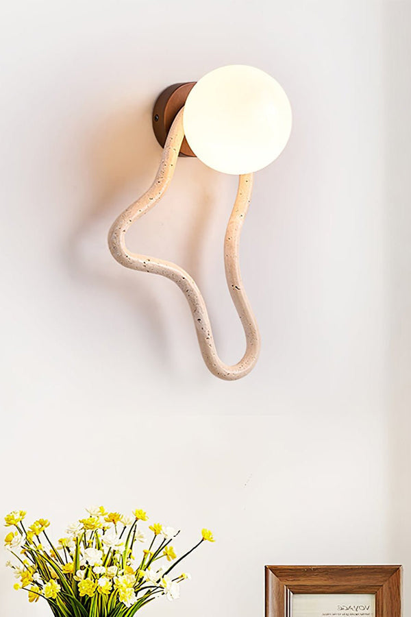Lit travertine flow sconce with vertical orientation | Travertine, Glass, Wood | Detailed shot above a floral arrangement | vexa lamps