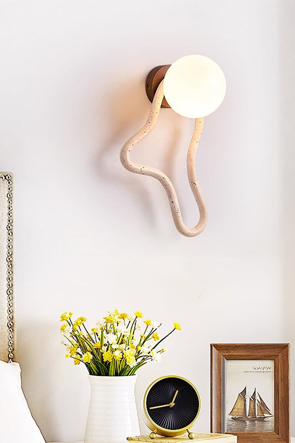 Travertine flow wall sconce in a decorated corner | Travertine, Glass, Wood | Near a vase of flowers and a vintage clock | vexa lamps