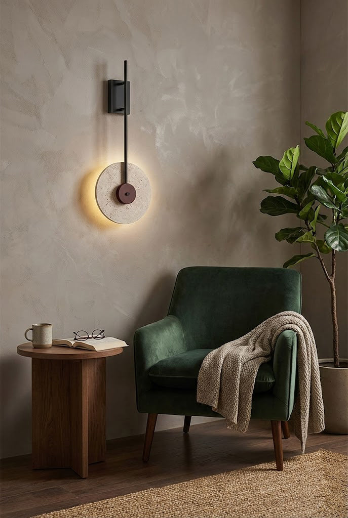 Modern travertine disc wall lamp providing backlighting | Travertine, Wood, Metal | Next to a green armchair in a minimalist lounge | vexa lamps
