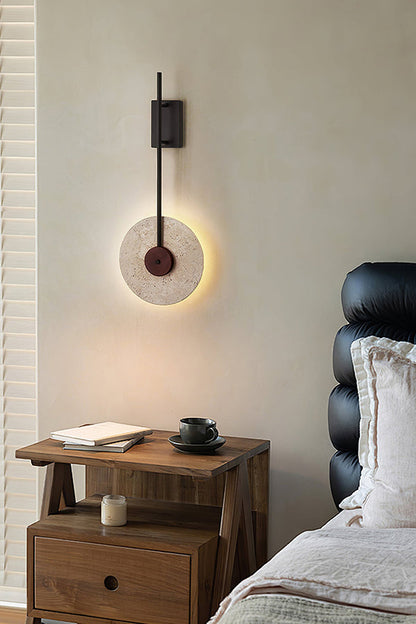 Modern travertine sconce in a luxury bedroom | Travertine, Wood, Metal | Next to a black leather headboard | vexa lamps