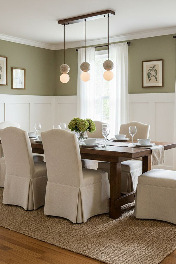 Linear travertine pendant light over dining table | Yellow Travertine, Glass | Installed in a formal dining room with slipcovered chairs | vexa lamps