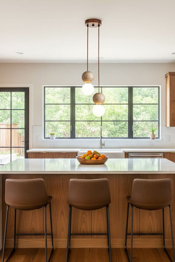 2-light linear stone pendant over kitchen counter | Yellow Travertine, Glass | Modern kitchen interior with brown leather stools | vexa lamps