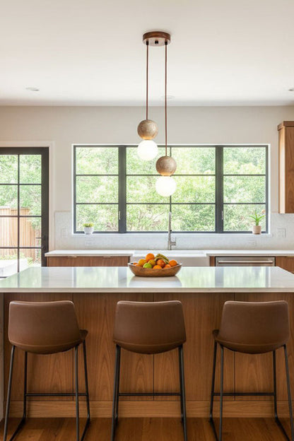 2-light linear stone pendant over kitchen counter | Yellow Travertine, Glass | Modern kitchen interior with brown leather stools | vexa lamps