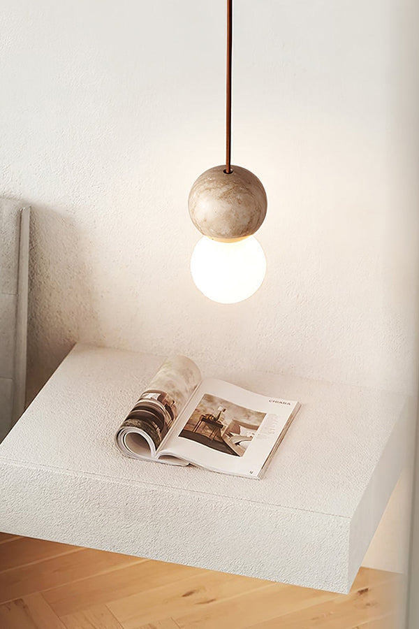 Single travertine pendant over a textured pedestal | Yellow Travertine, Glass | Minimalist interior scene with natural stone | vexa lamps