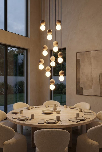 Large cascading travertine cluster chandelier | Yellow Travertine, Glass | Centered over a round dining table in a high-ceiling room | vexa lamps