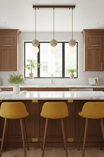 3-light linear travertine stone pendant | Yellow Travertine, Glass | Installed over a kitchen island with yellow bar stools | vexa lamps