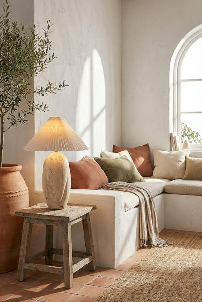Organic stone lamp in a sunlit room | Travertine, Fabric | On a small wooden stool near a white sofa | vexa lamps