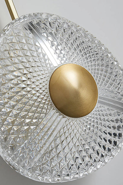 Vara Aura Woven Acrylic Wall Lamp | Woven Acrylic, Brass | Close-up shot focusing on the intricate woven pattern of the clear acrylic shade and central brass disc | vexa lamps