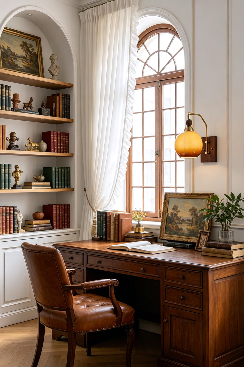 Vesper Caramel Gradient Wall Lamp | Glass, Metal, Wood | Providing a warm ambient glow on the wall of a traditional home office workspace with an executive desk and open bookshelves | vexa lamps