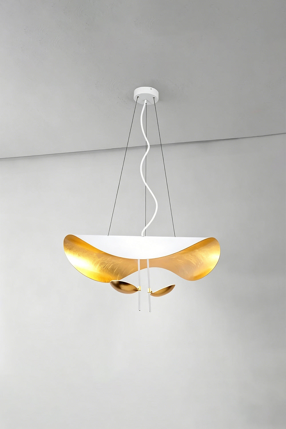 Voluta Horizon Metal Pendant Light | Metal | White and gold variant illuminated against a simple plain wall corner | vexa lamps