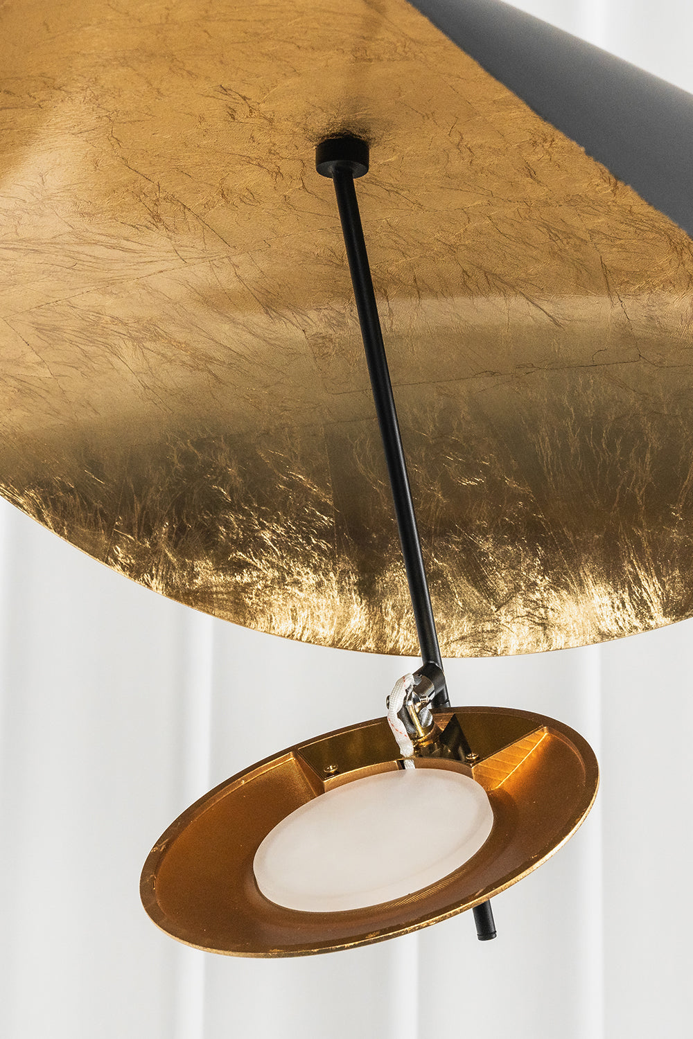 Voluta Horizon Metal Pendant Light | Metal | Close-up view from underneath focusing on the small suspended gold foil accent disc | Detail shot | vexa lamps