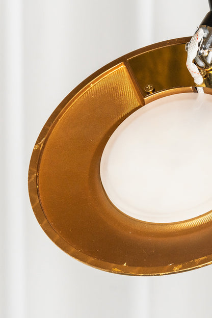 Voluta Horizon Metal Pendant Light | Metal | Close-up of the glowing circular white diffuser set within a polished gold metal ring | Detail shot | vexa lamps
