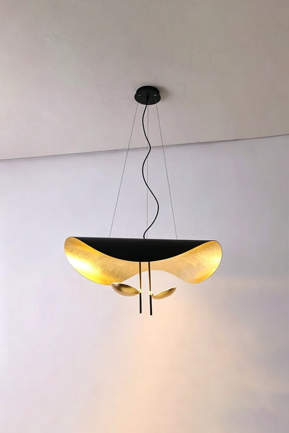 Voluta Horizon Metal Pendant Light | Metal | Black and gold variant illuminated against a simple plain wall corner | vexa lamps