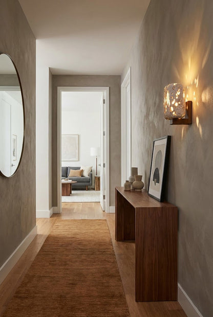 Travertine cylinder wall lamp in a long hallway | Travertine, Wood | Installed above a slim wooden console table | vexa lamps
