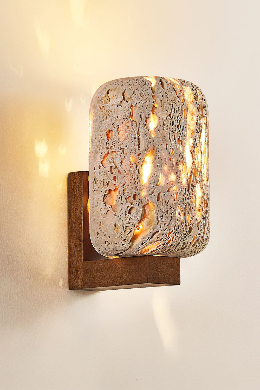 Close-up of lit Wabi-Sabi travertine wall lamp | Travertine, Wood | Showing the porous stone texture and wooden bracket | vexa lamps