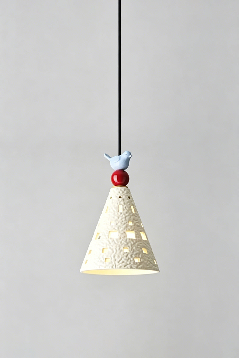 Whimsy Ceramic & Resin Pendant Light featuring a textured cone shade and sculptural bird detail.
