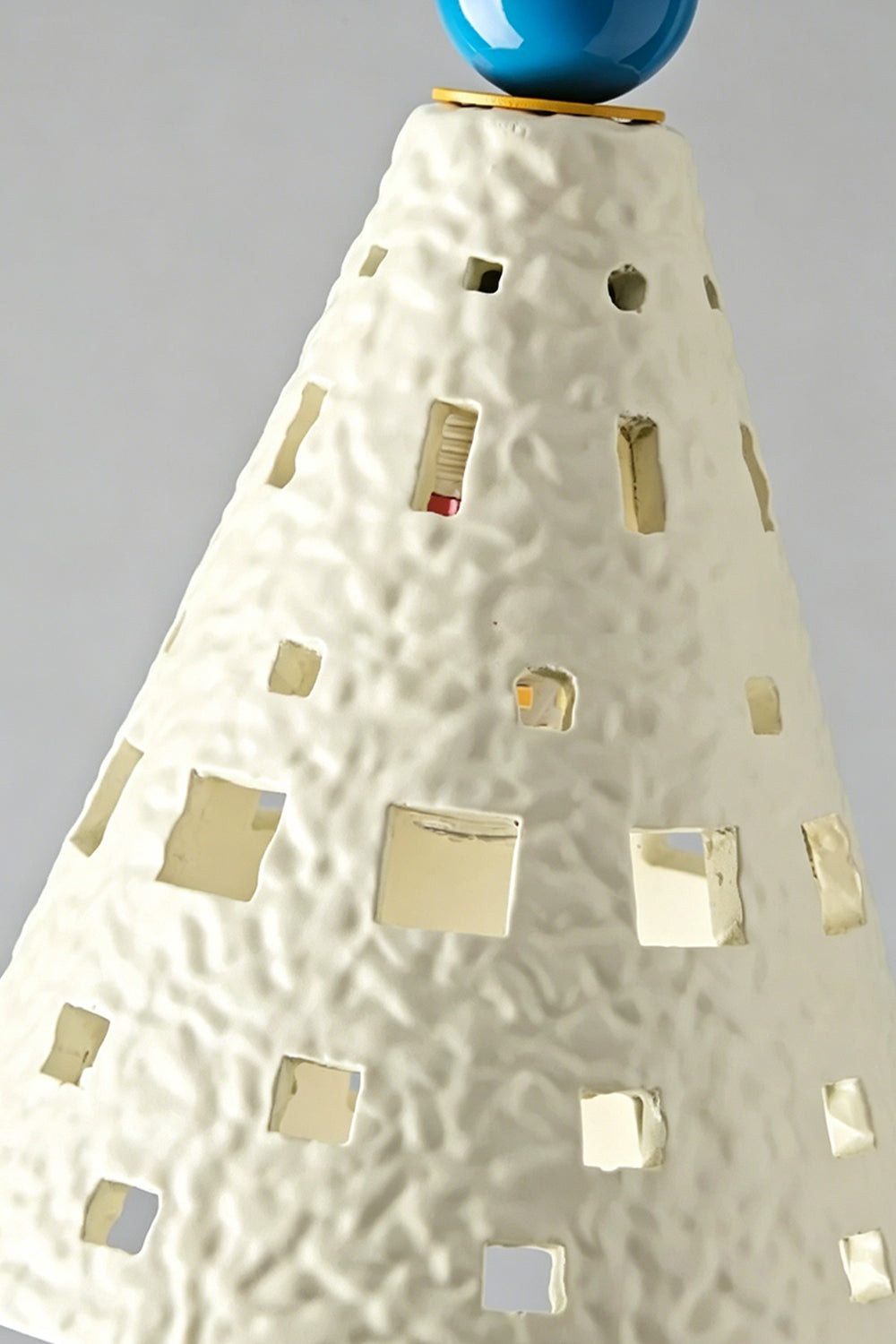 Whimsy Ceramic & Resin Pendant Light featuring a textured cone shade with geometric cutouts in cream color.