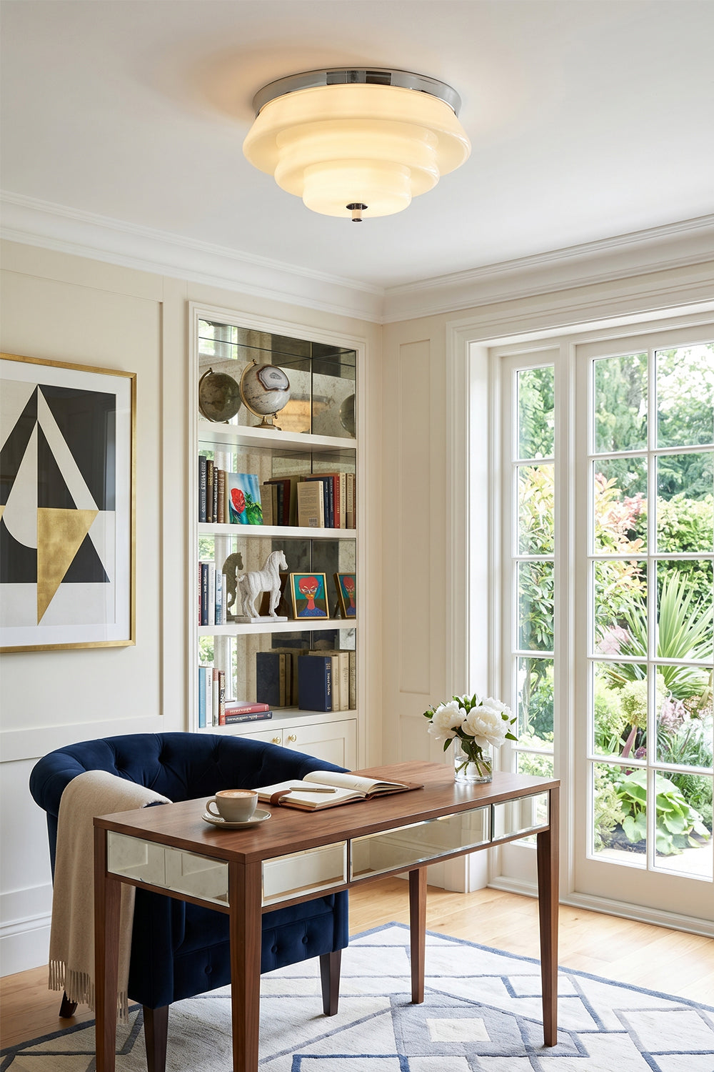 Ziggurat Horizon Glass Ceiling Light illuminating a stylish home office with modern decor and a view of greenery.